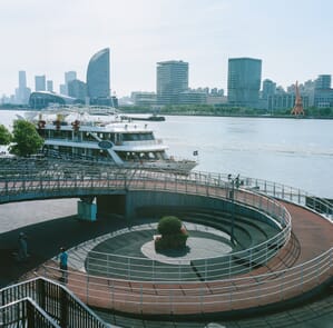 a boat on a river with a bridge and a city in the background