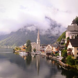 A picturesque village nestled by a calm lake and mountains.